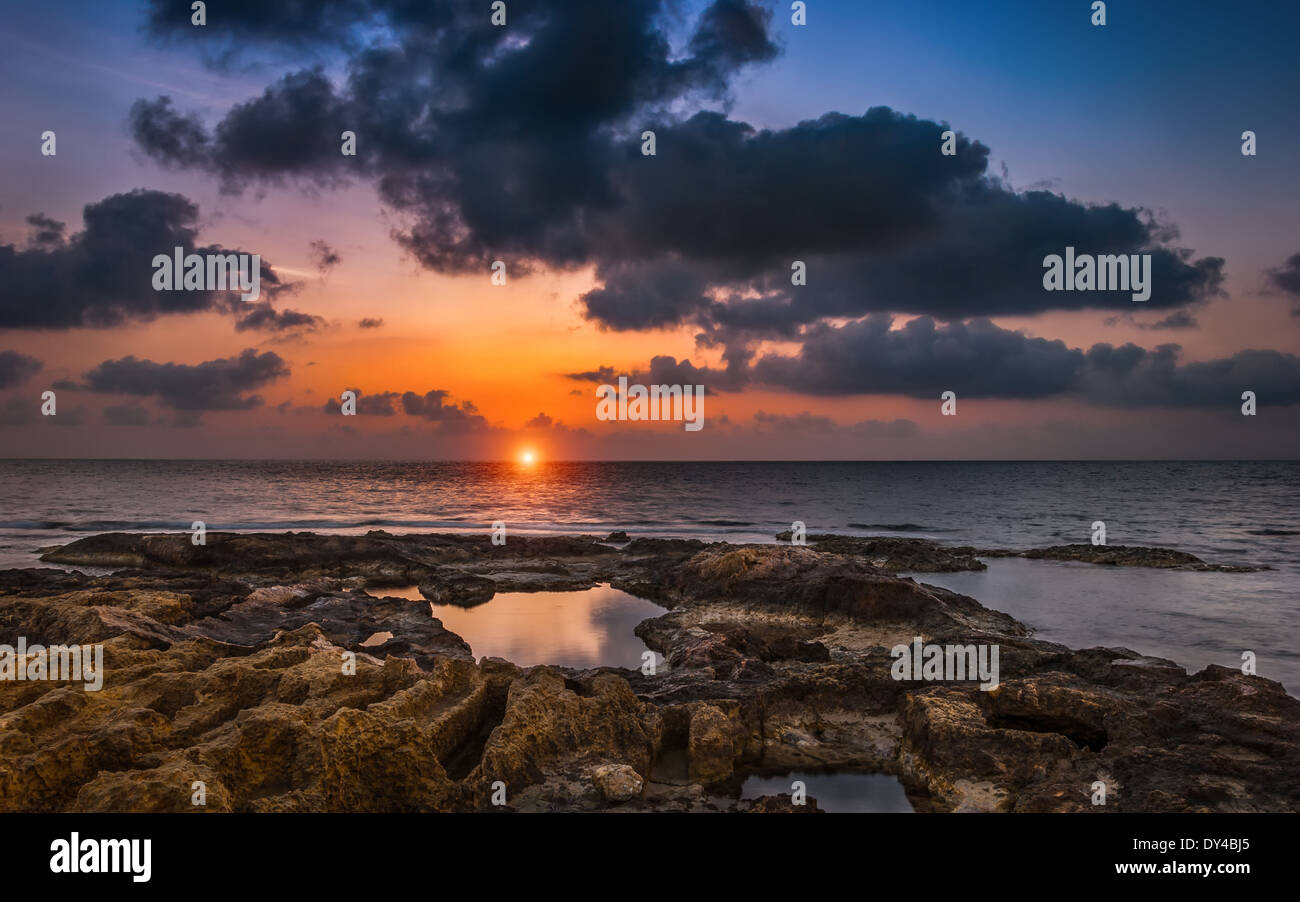 Cloudy Sunset over the Sea and Rocky Beach Stock Photo - Alamy