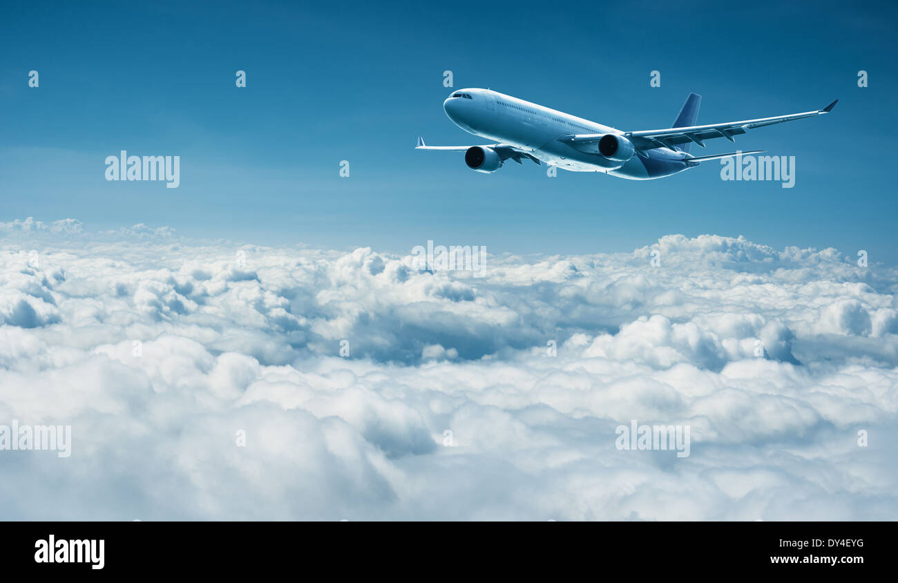 Passenger plane flies above the clouds - air travel Stock Photo