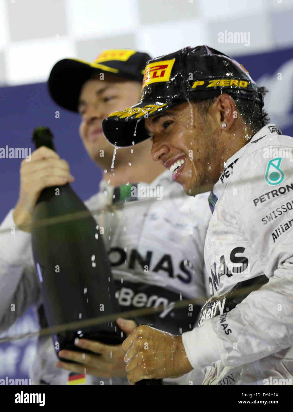 Manama, Bahrain. 06th Apr, 2014. Mercedes' Lewis Hamilton (R) and Nico Rosberg celebrate after the final of Formula 1 Bahrain Grand Prix in Manama, Bahrain, on April 6, 2014. Hamilton won the title with 1 hour 39 minutes and 42.743 seconds.  Credit:  Hasan Jamali/Xinhua/Alamy Live News Stock Photo