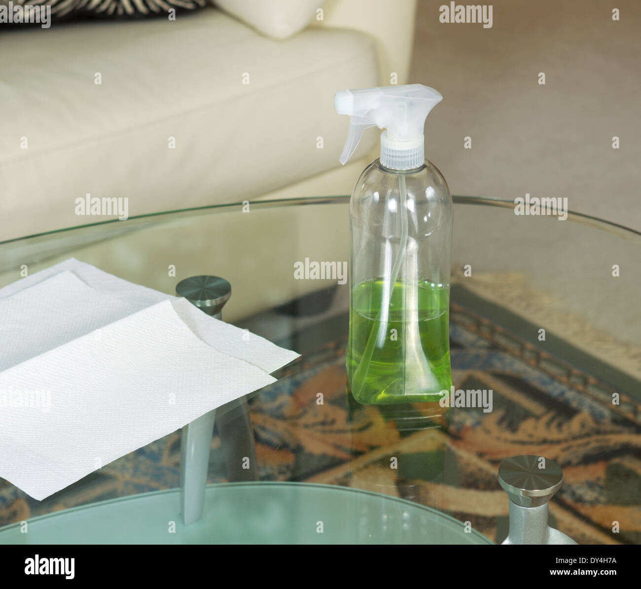 Photo of cleaning solution, in spray bottle, on dirty glass table with