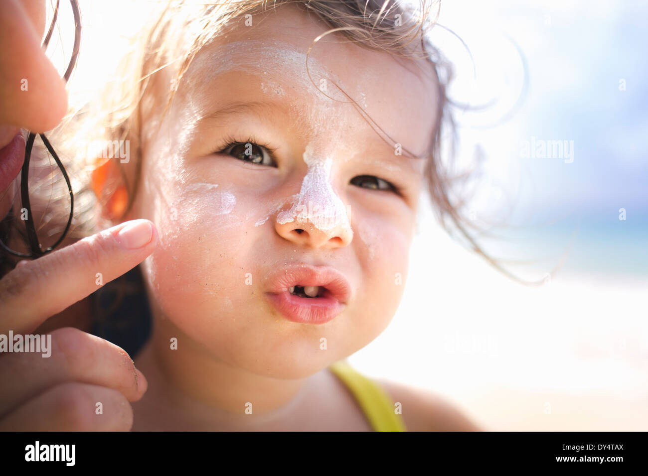 Mother putting sun cream on daughter's face Stock Photo