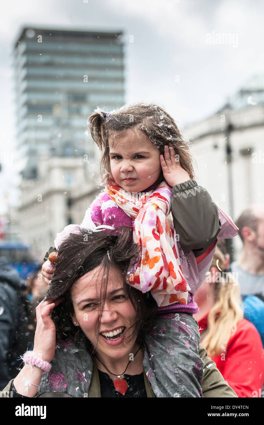 A toddler sitting on her mother's shoulders during the International Pillow Fight Day. Stock Photo