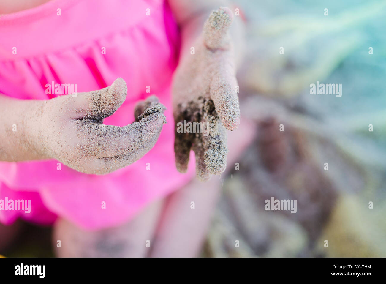 Toddler's hands, covered in sand Stock Photo