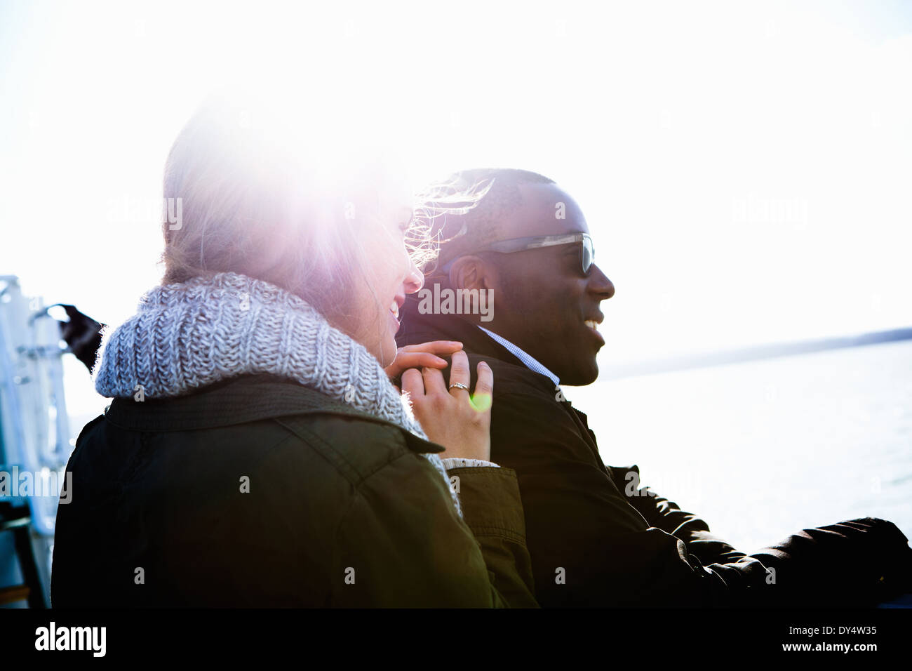 Young couple sitting outdoors in sunlight Stock Photo