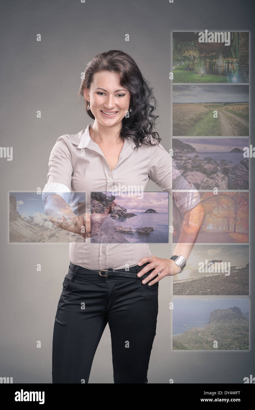studio portrait of a young woman by viewing of holiday pictures Stock Photo