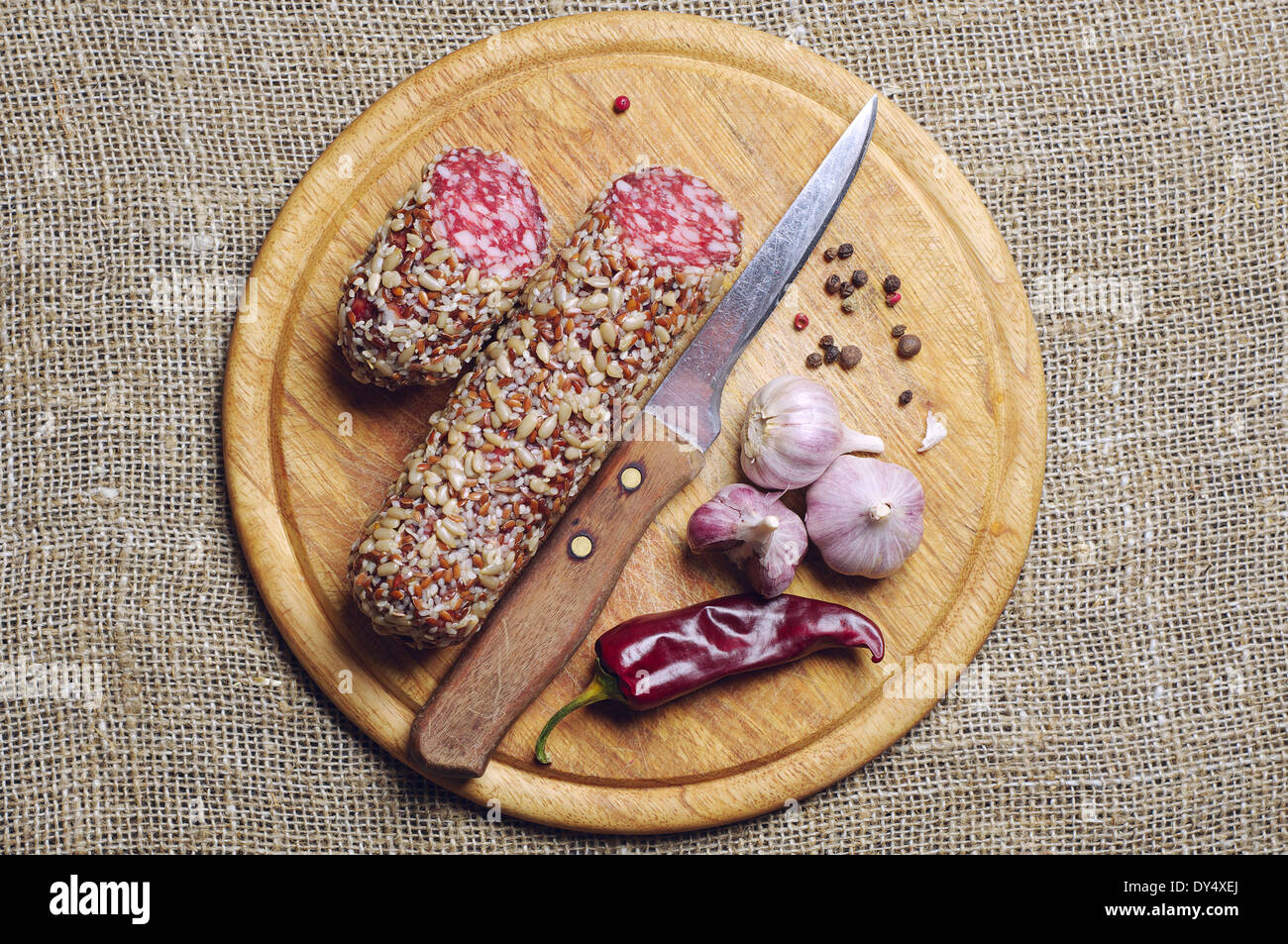 Sausage with sunflower seeds, red chili and garlic on cutting board Stock Photo