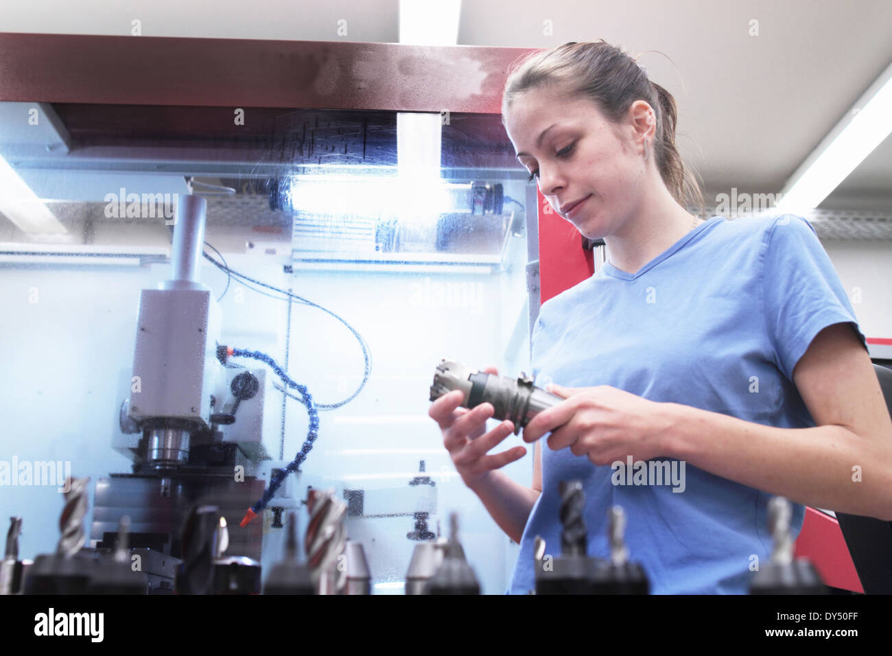 Female engineer checking tool in workshop Stock Photo