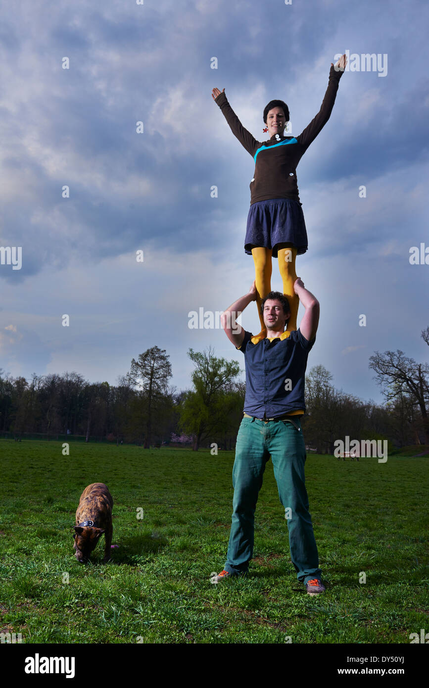 Young woman standing on man's shoulders in the park Stock Photo Alamy