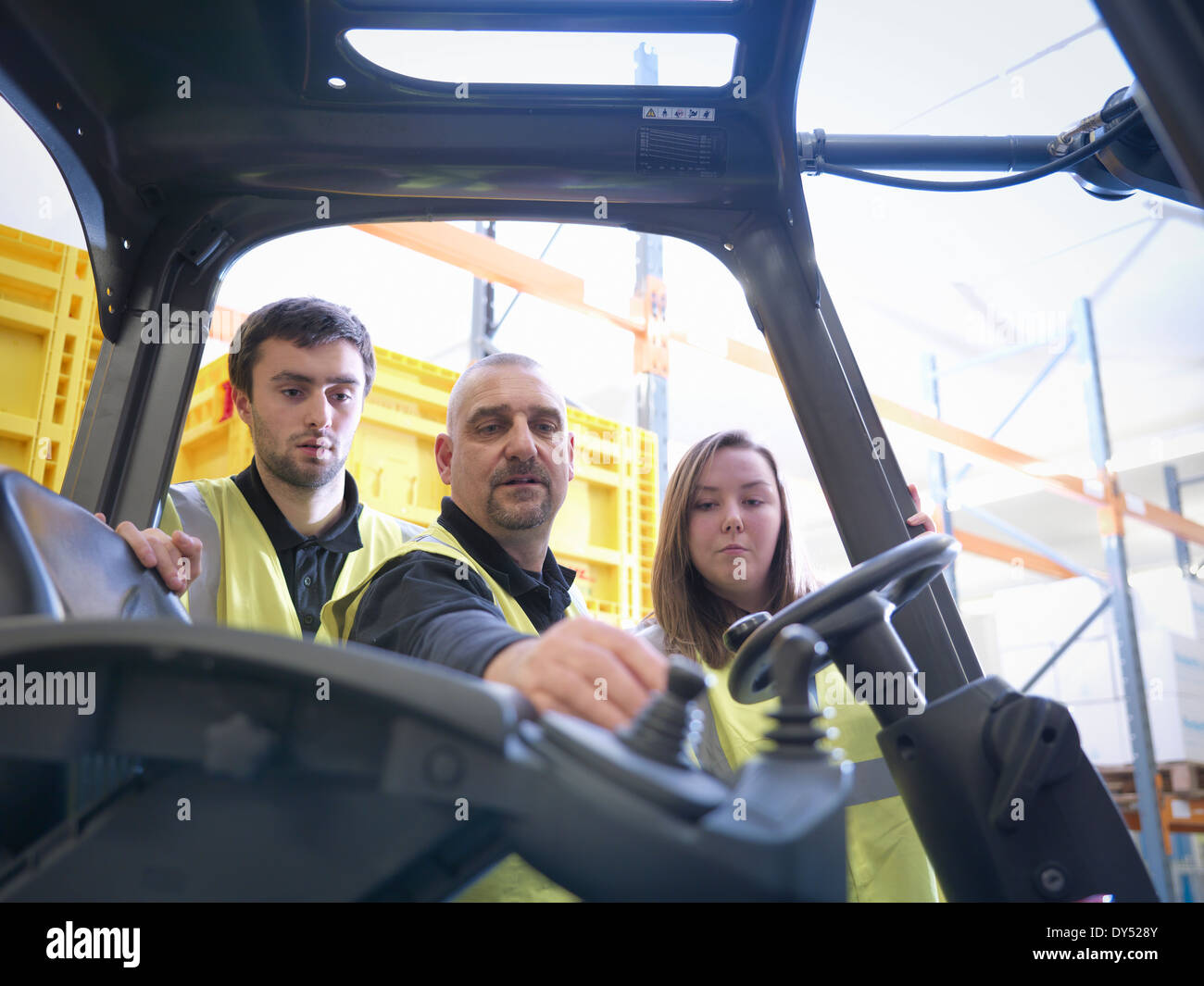 Instructor showing apprentices controls of forklift truck Stock Photo
