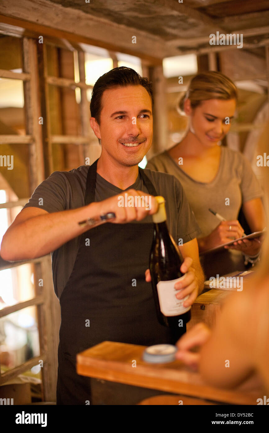 Sommelier opening bottle of wine in wine shop Stock Photo Alamy