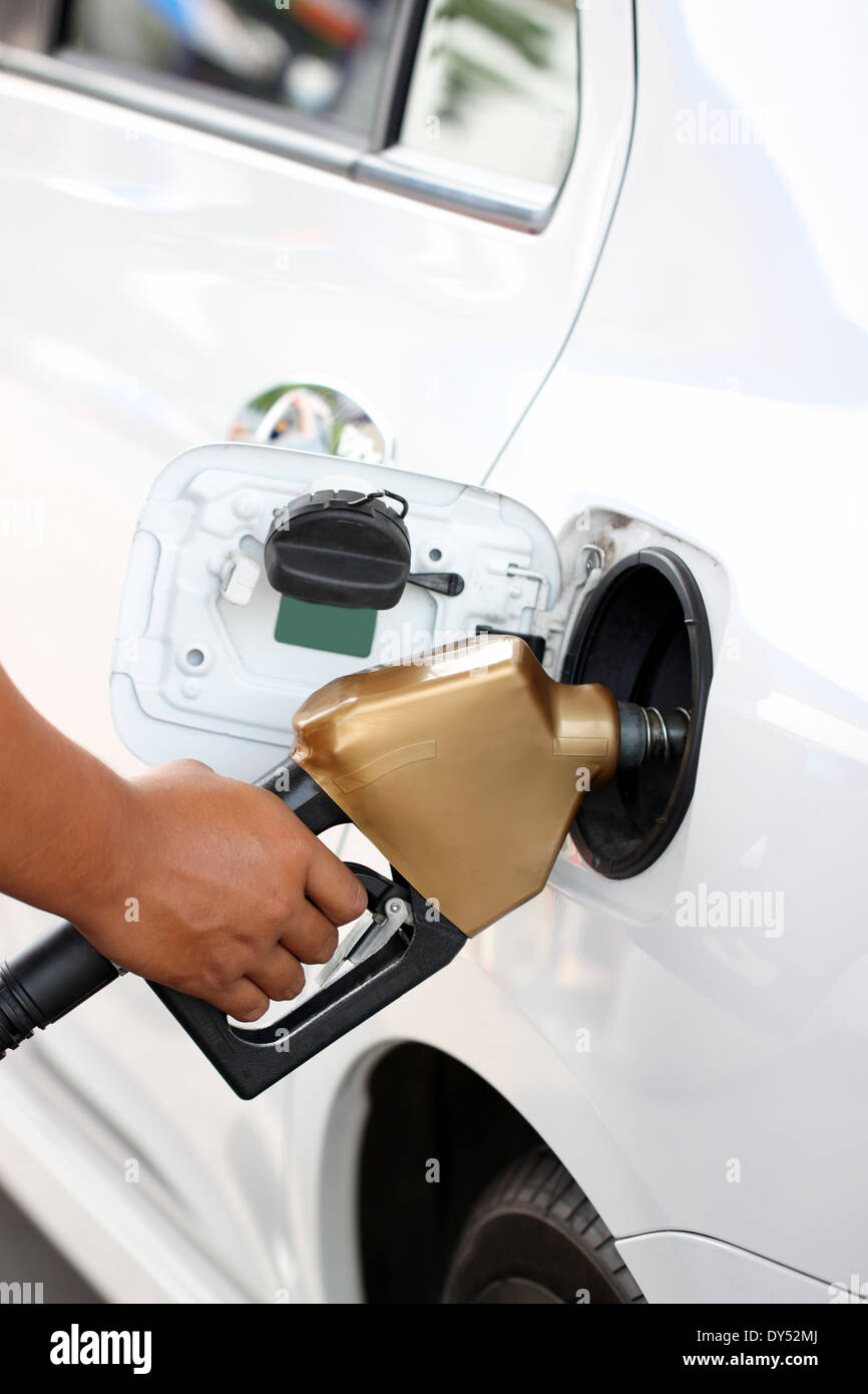 Hand that are refueling to white car. Stock Photo