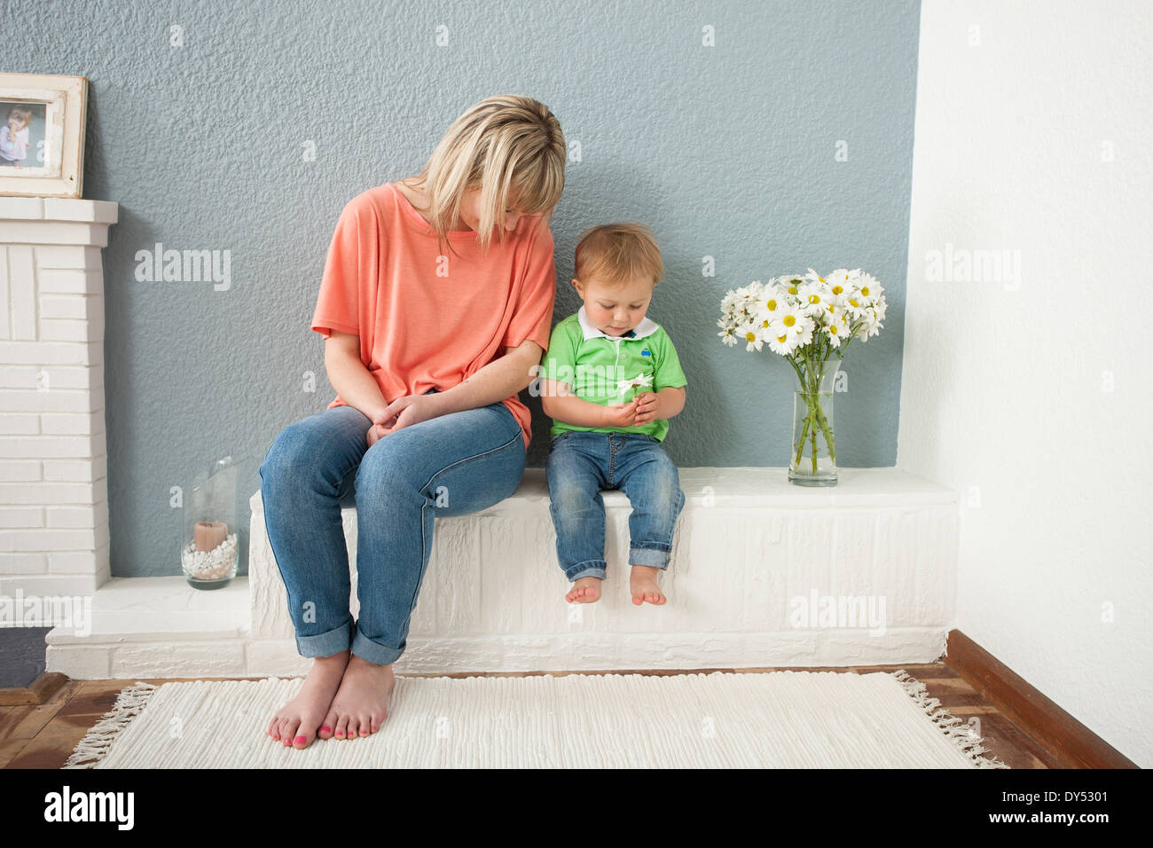 Young woman and baby boy playing with flowers Stock Photo