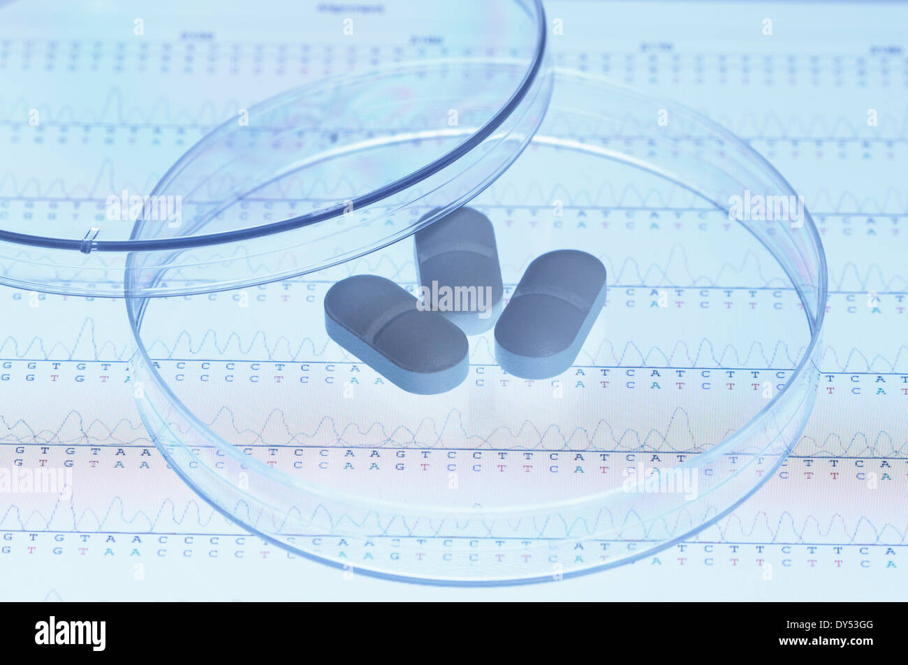 Genetic research. Pills in a Petri dish on the screen of a tablet computer that displays results of automated DNA sequencing Stock Photo