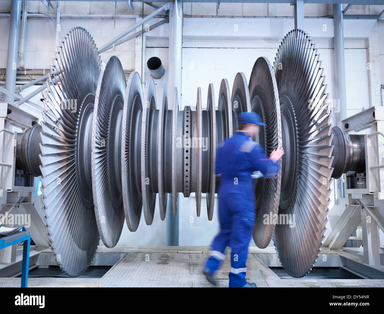 Engineer inspecting steam turbine blades in repair bay of workshop Stock Photo