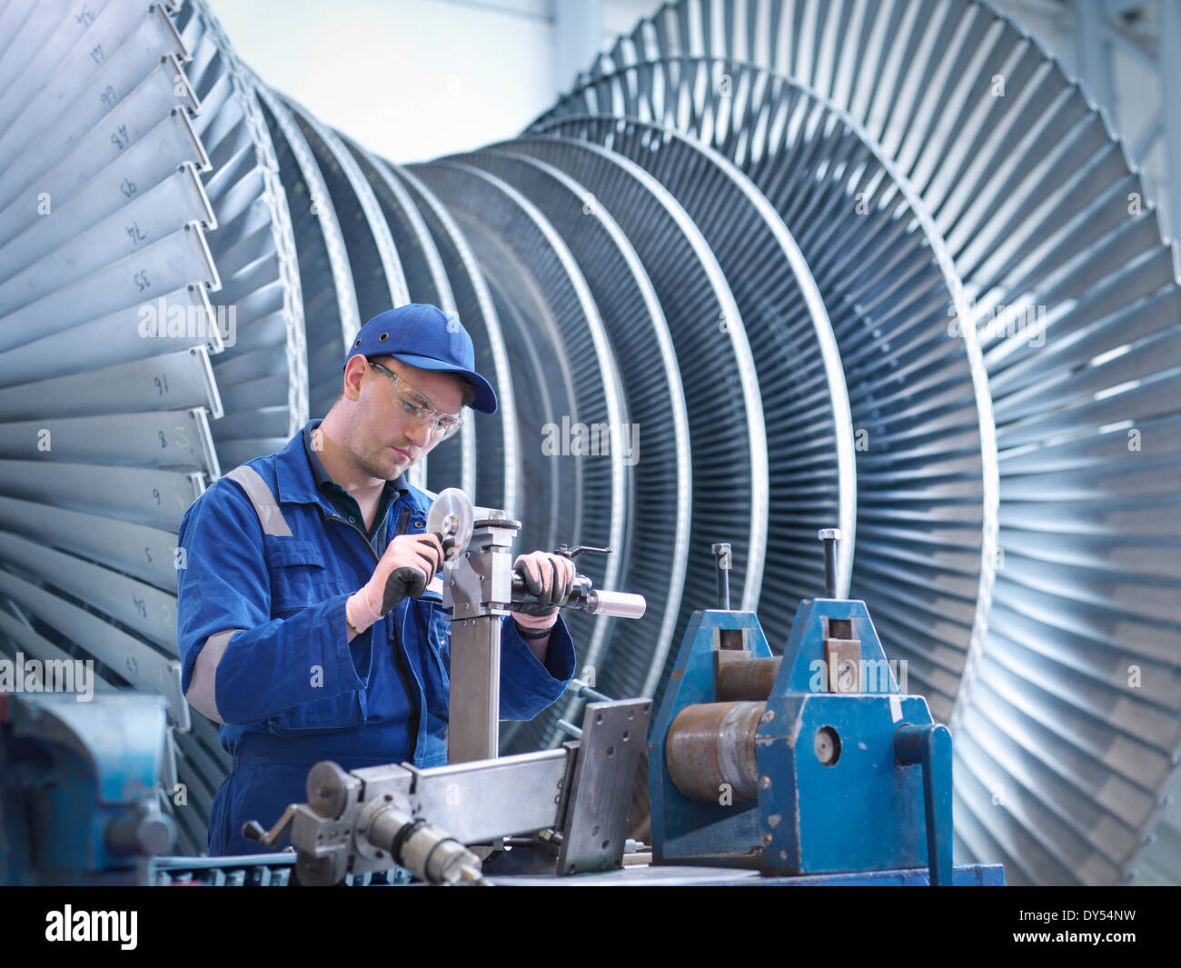 Engineer at workstation in front of steam turbine Stock Photo