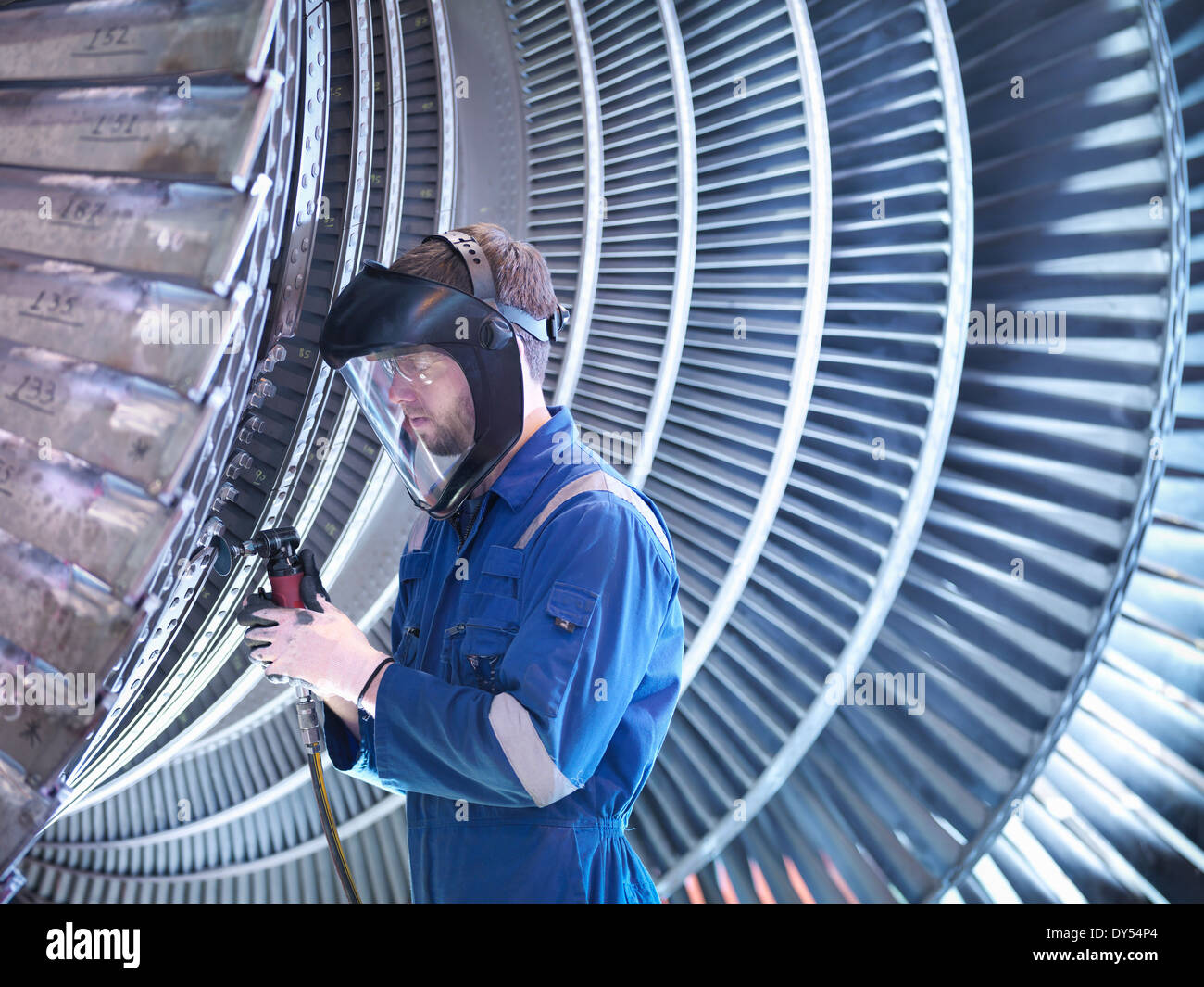 Engineer repairing steam turbine blade with grinder in workshop Stock Photo
