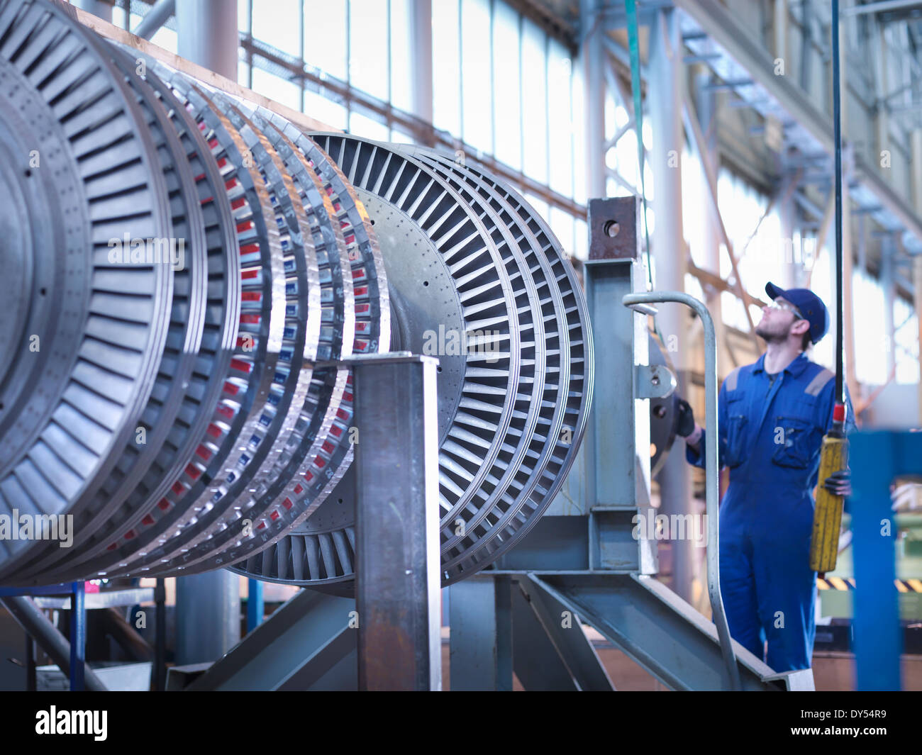 Engineer lifting high pressure steam turbine with crane in workshop Stock Photo