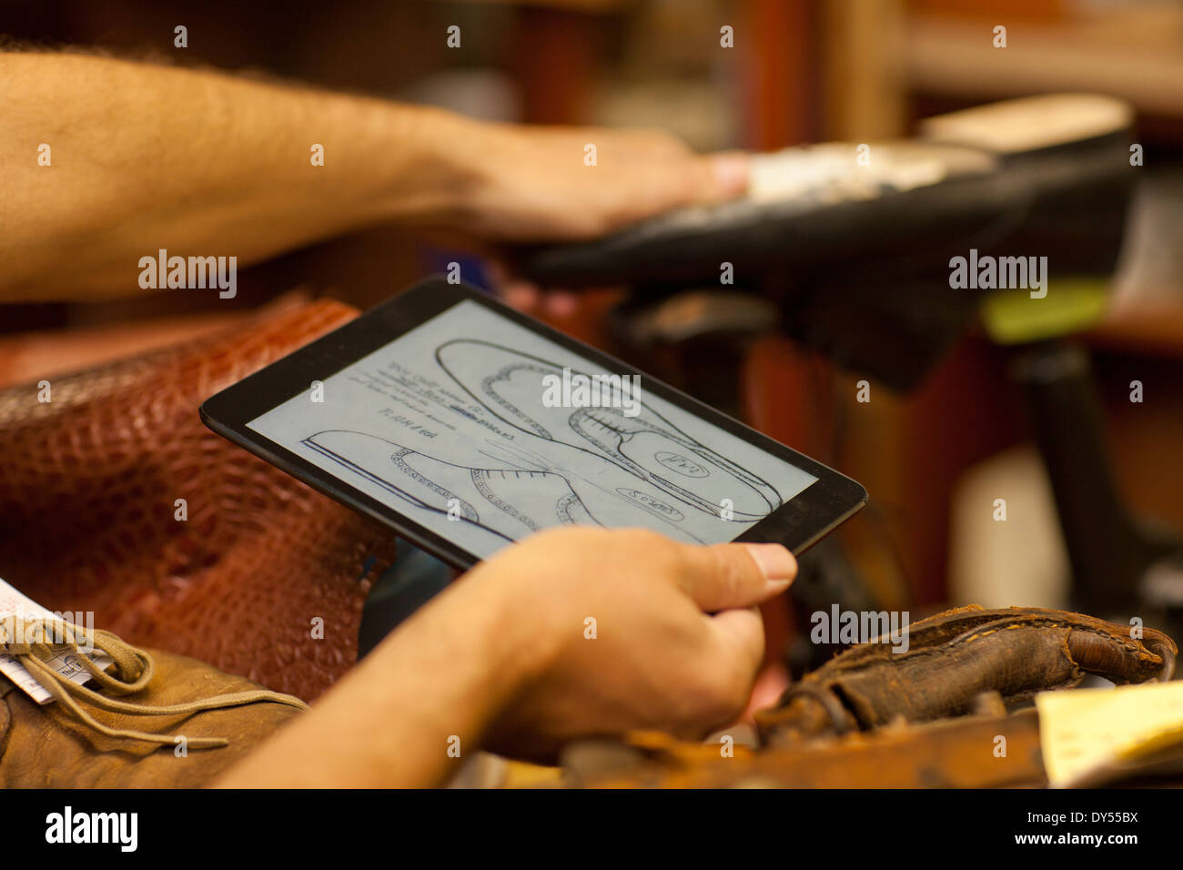 Cobbler holding digital tablet Stock Photo