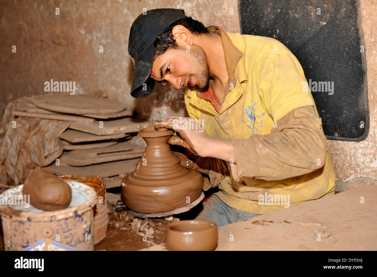 Craftsman potter throwing, making, a pot using a kick wheel in Morocco