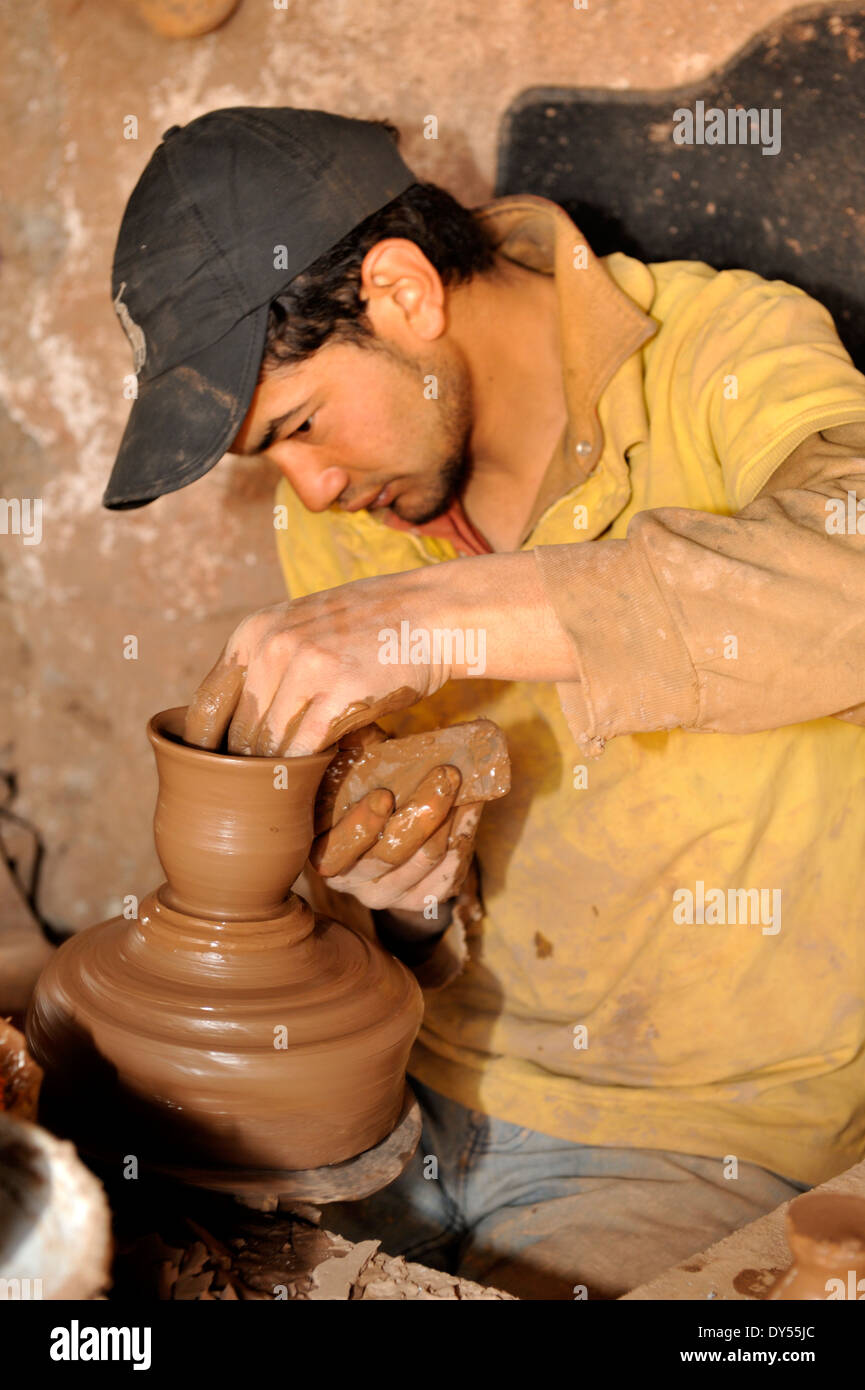 Craftsman potter throwing, making, a pot using a kick wheel in Morocco