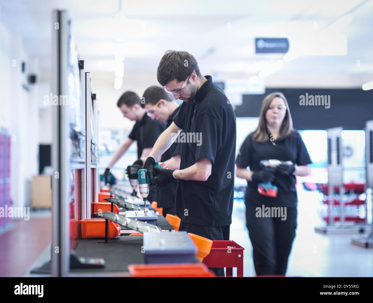 Apprentices working on training production line Stock Photo