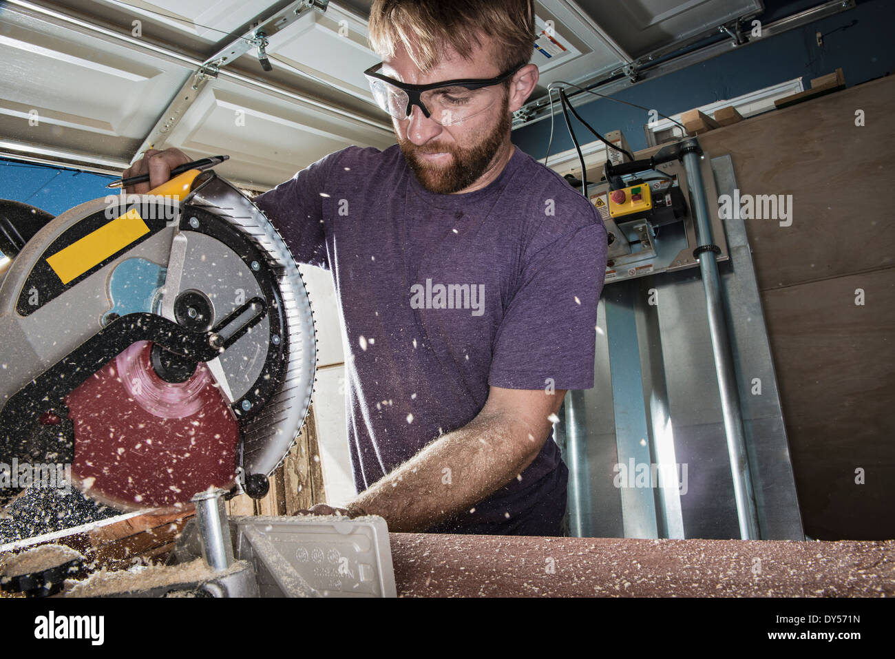 Joiner in garage using circular saw Stock Photo Alamy