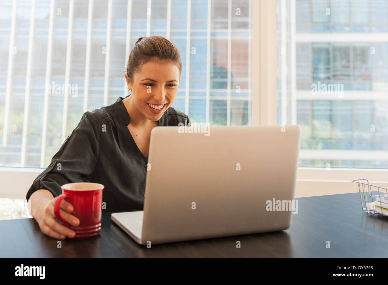 Young businesswoman taking a coffee break in office Stock Photo - Alamy