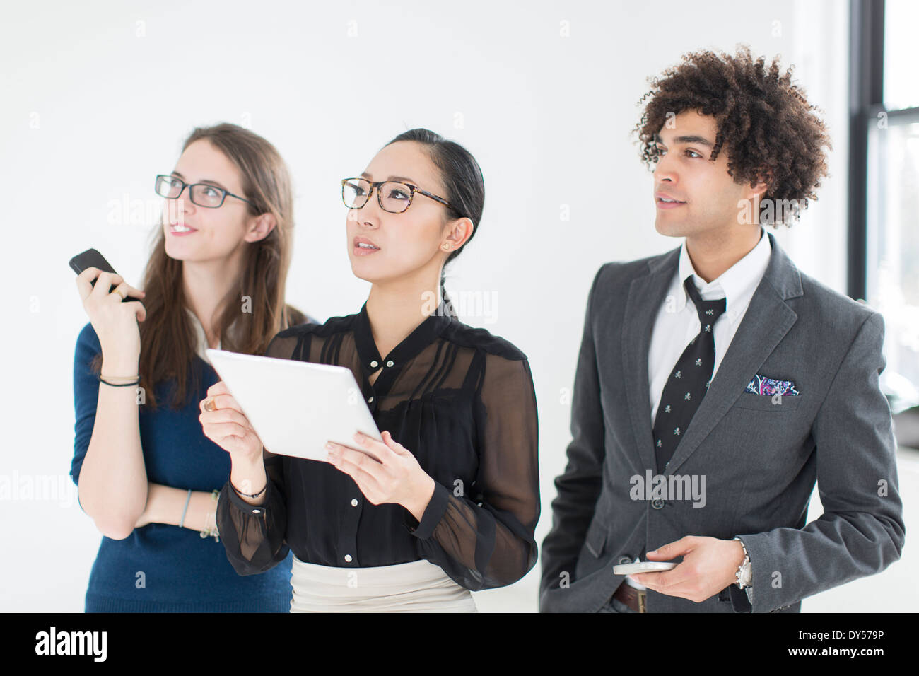 Three colleagues using digital tablet Stock Photo