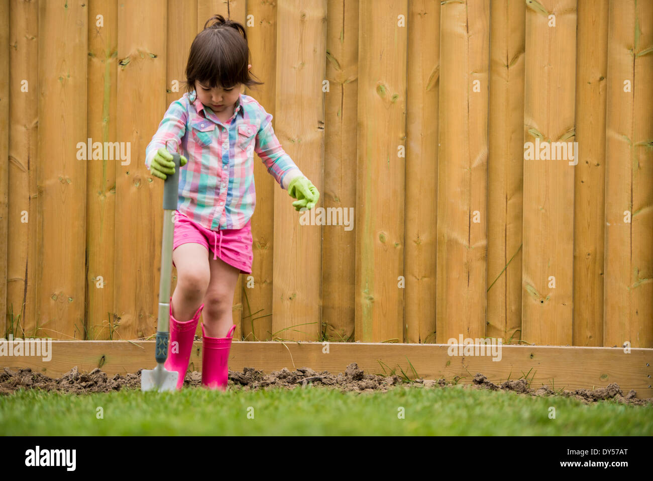 Young girl digging soil in the garden Stock Photo