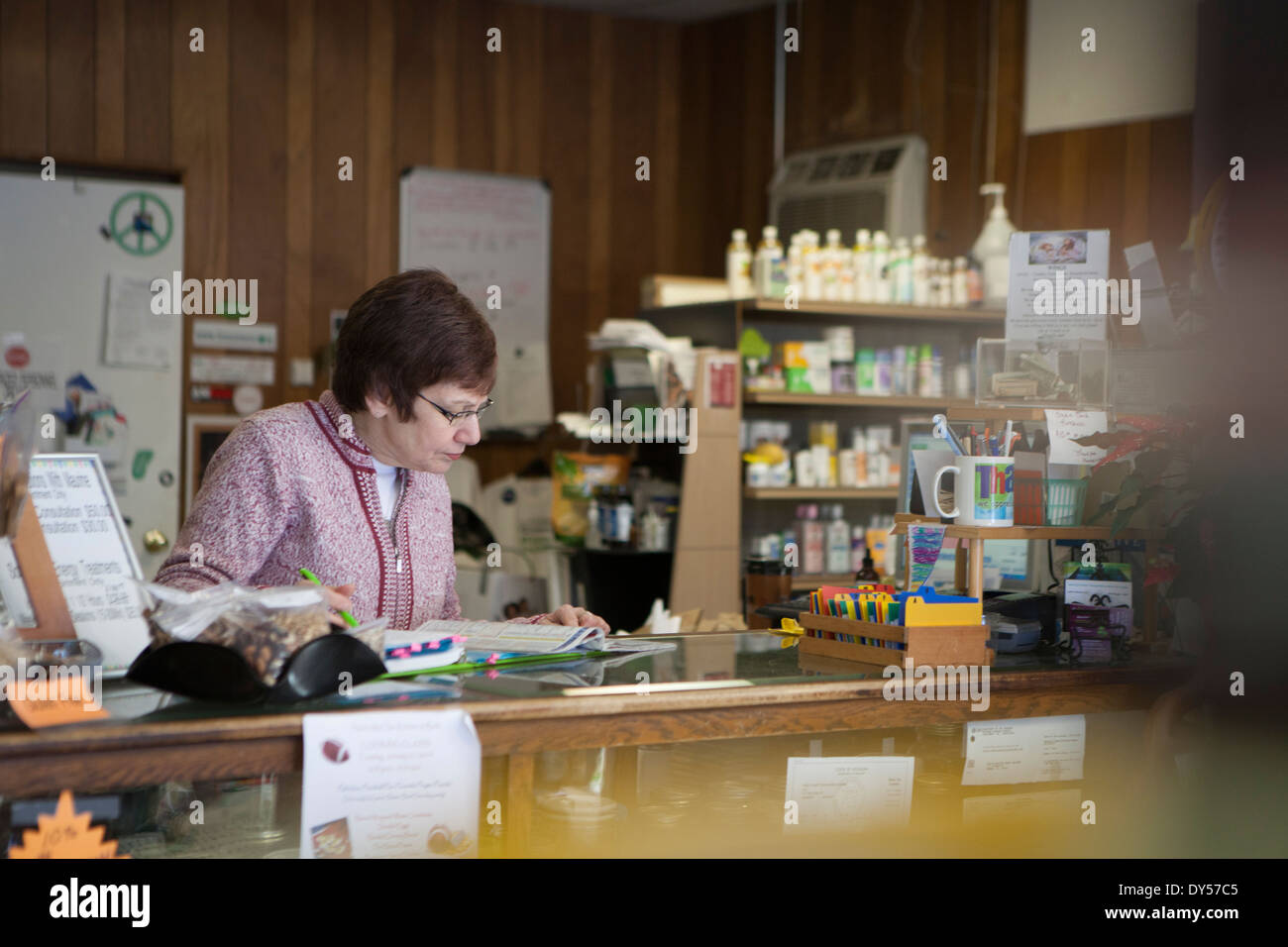 Health foods store owner working at counter Stock Photo
