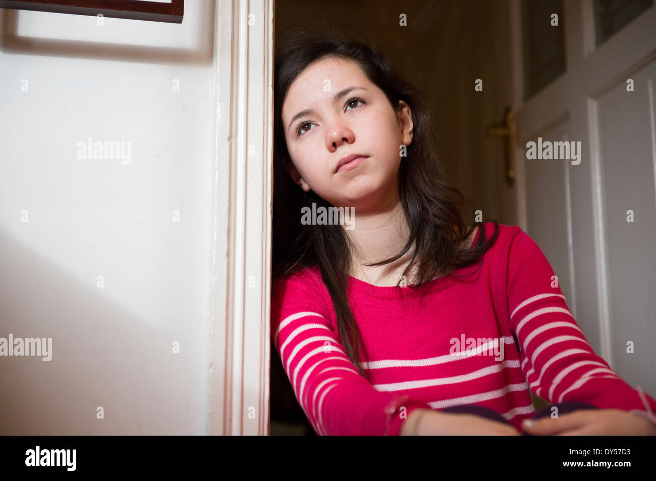 Girl leaning against doorway Stock Photo