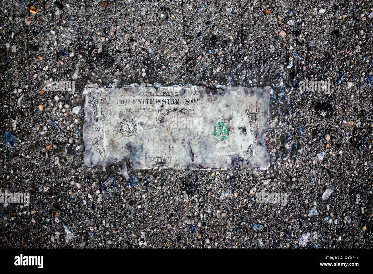 Still life of deteriorating one dollar bill on wet pavement Stock Photo
