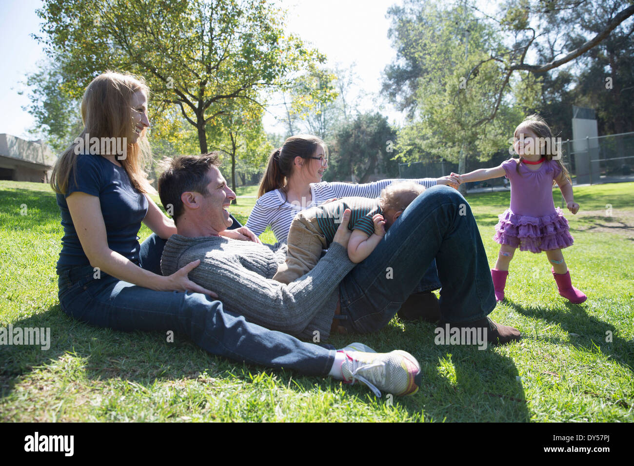 Happy family relaxing on grass Stock Photo - Alamy