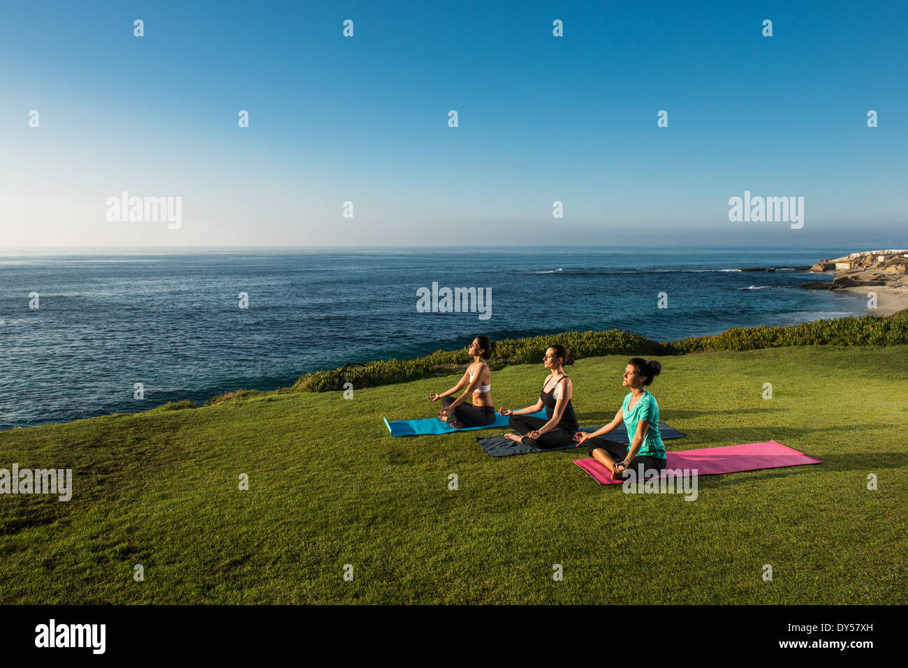 Women on cliff, meditating Stock Photo
