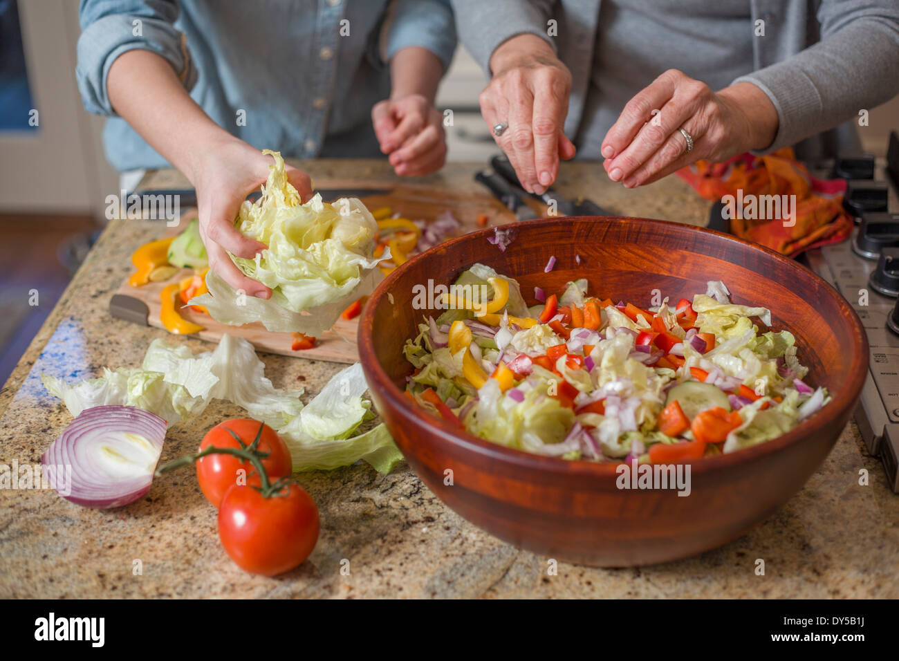 Senior woman and granddaughter chopping vegetables for salad Stock Photo