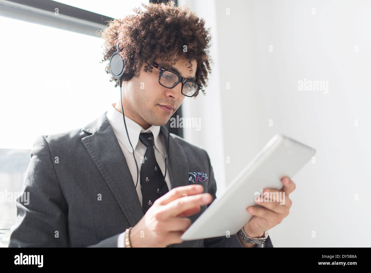 Young man wearing headphones using digital tablet Stock Photo