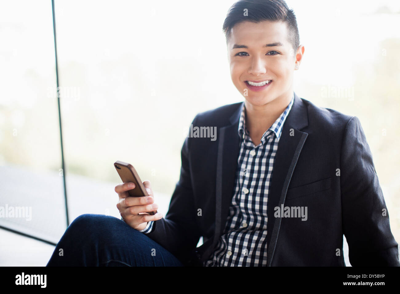 Portrait of young businessman holding smartphone Stock Photo