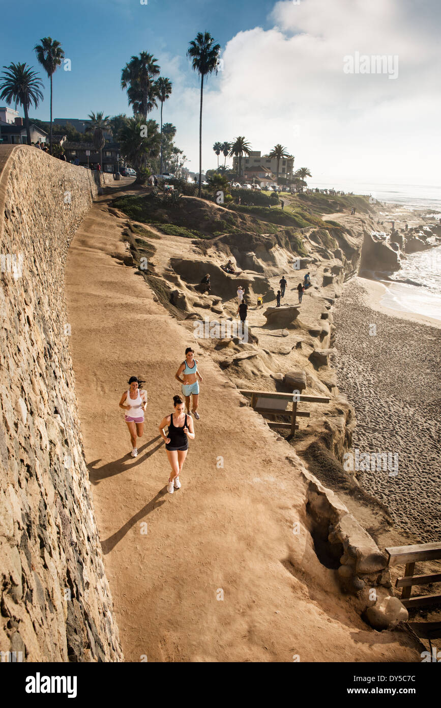 Mid adult women jogging along cliff Stock Photo