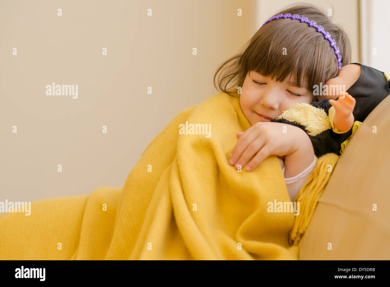 Young girl lying on sofa pretending to sleep Stock Photo
