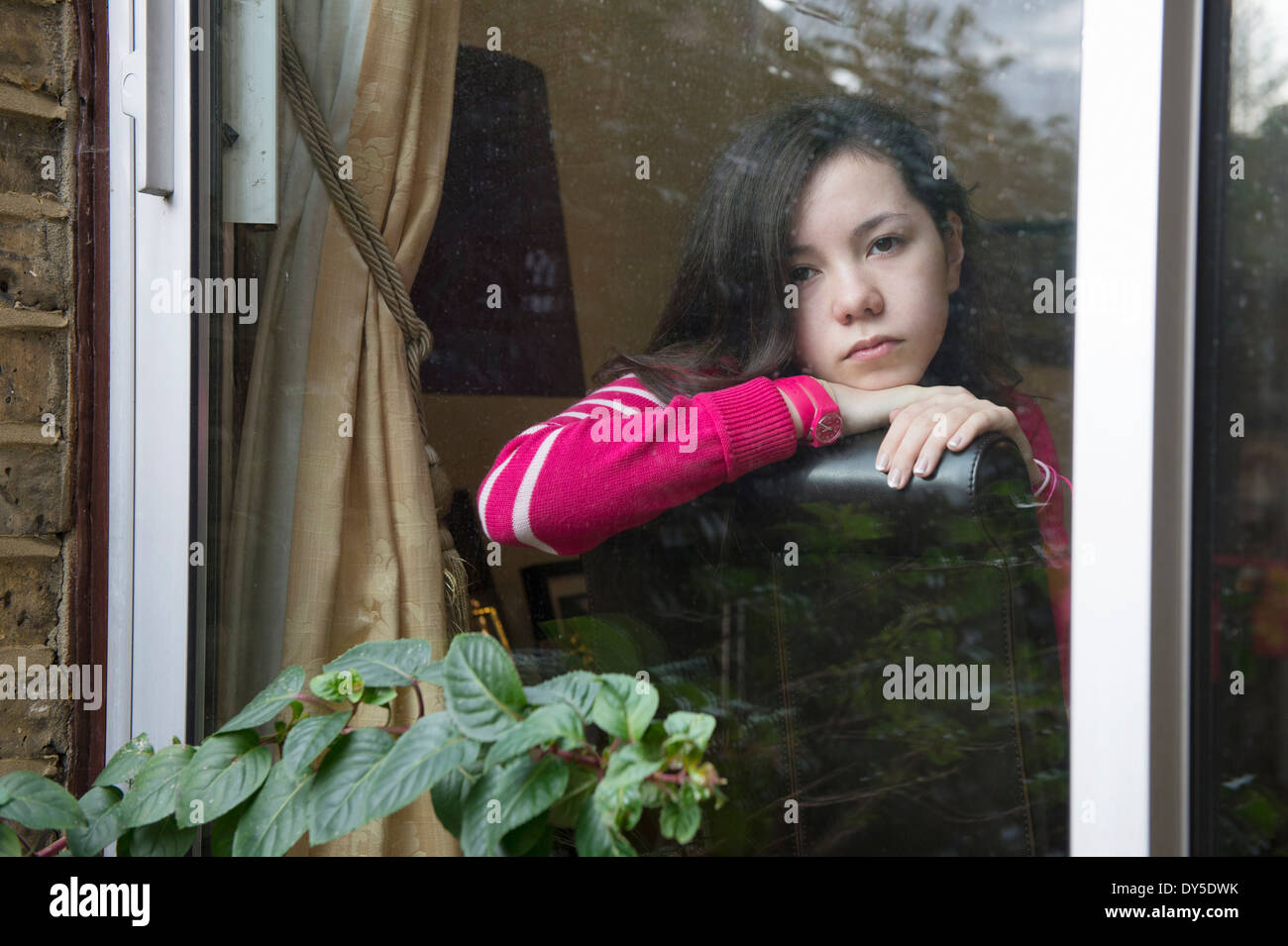 Girl looking through window Stock Photo