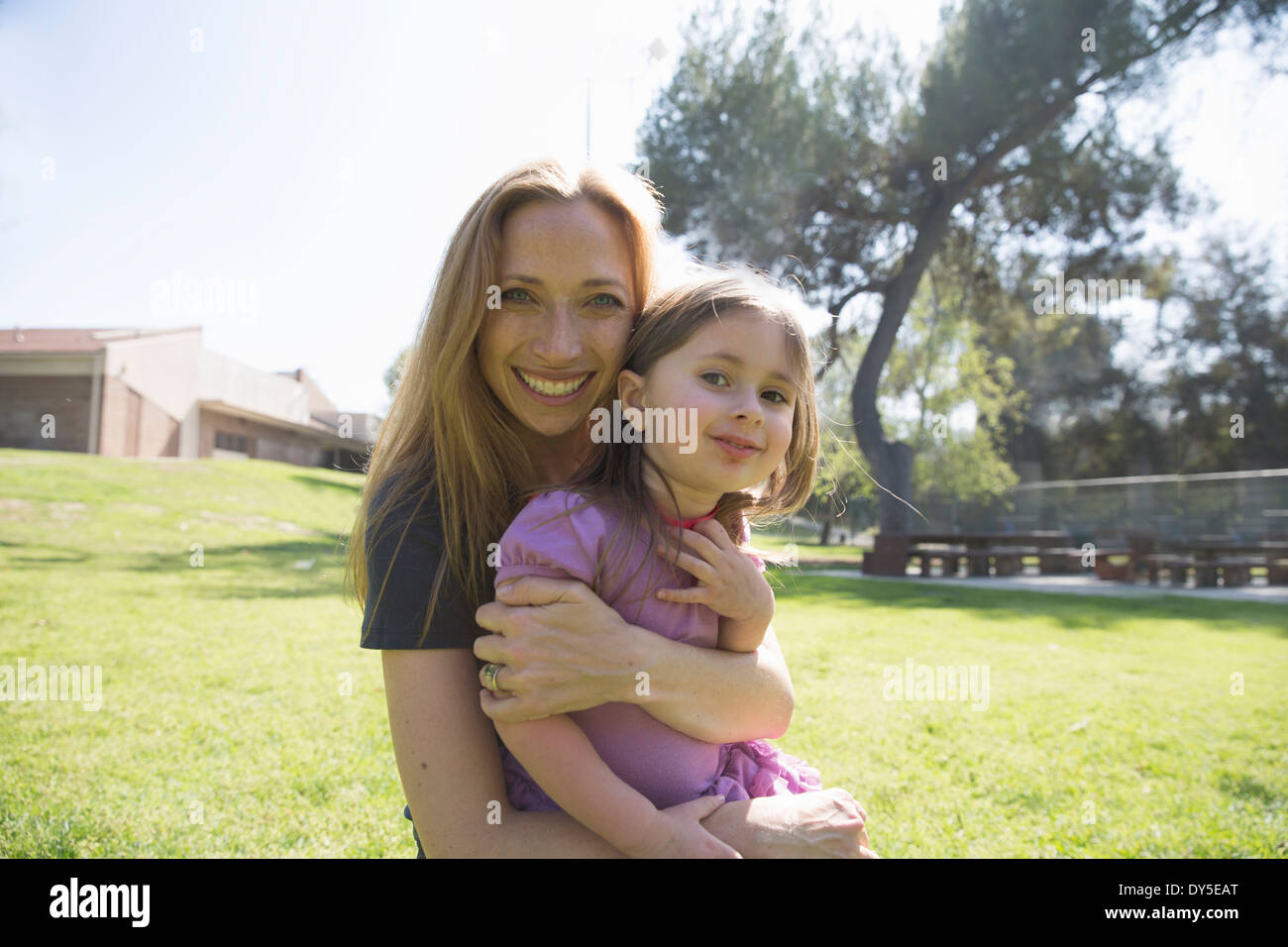 Mother hugging daughter in park Stock Photo