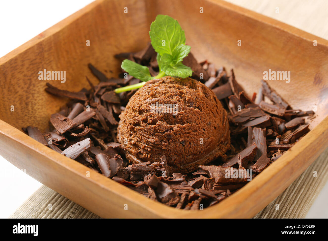 Scoop of ice cream and chocolate shavings in wooden bowl Stock Photo