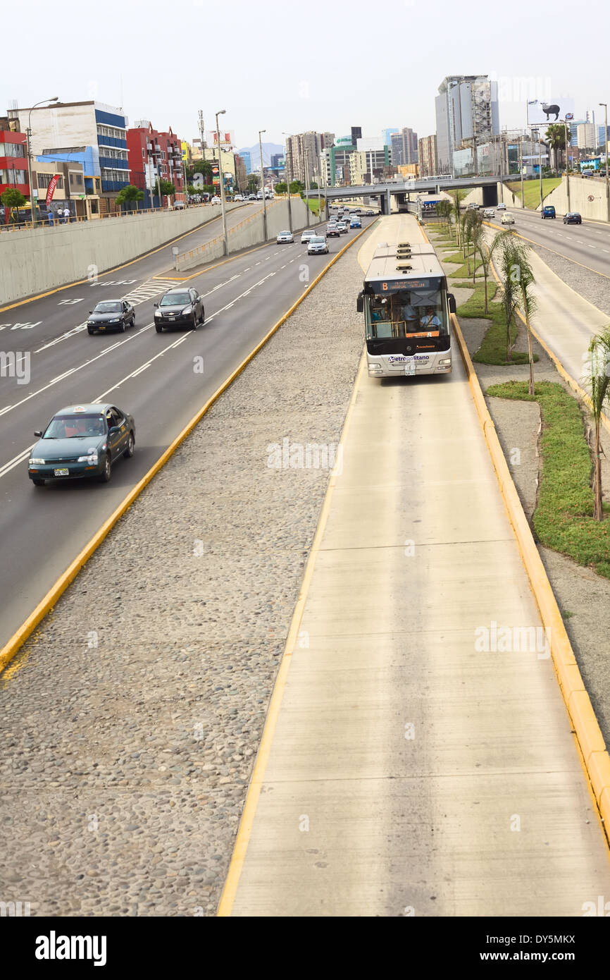 Metropolitano bus of Line B on the Paseo de la Republica Avenue with the bus stop at Angamos Avenue in the back in Lima, Peru Stock Photo
