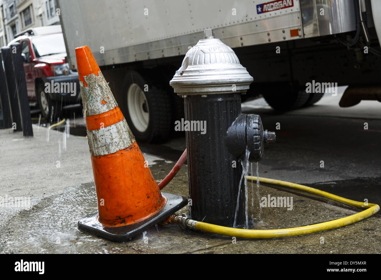 Leaking fire hydrant and warning cone closeup New York City Stock Photo