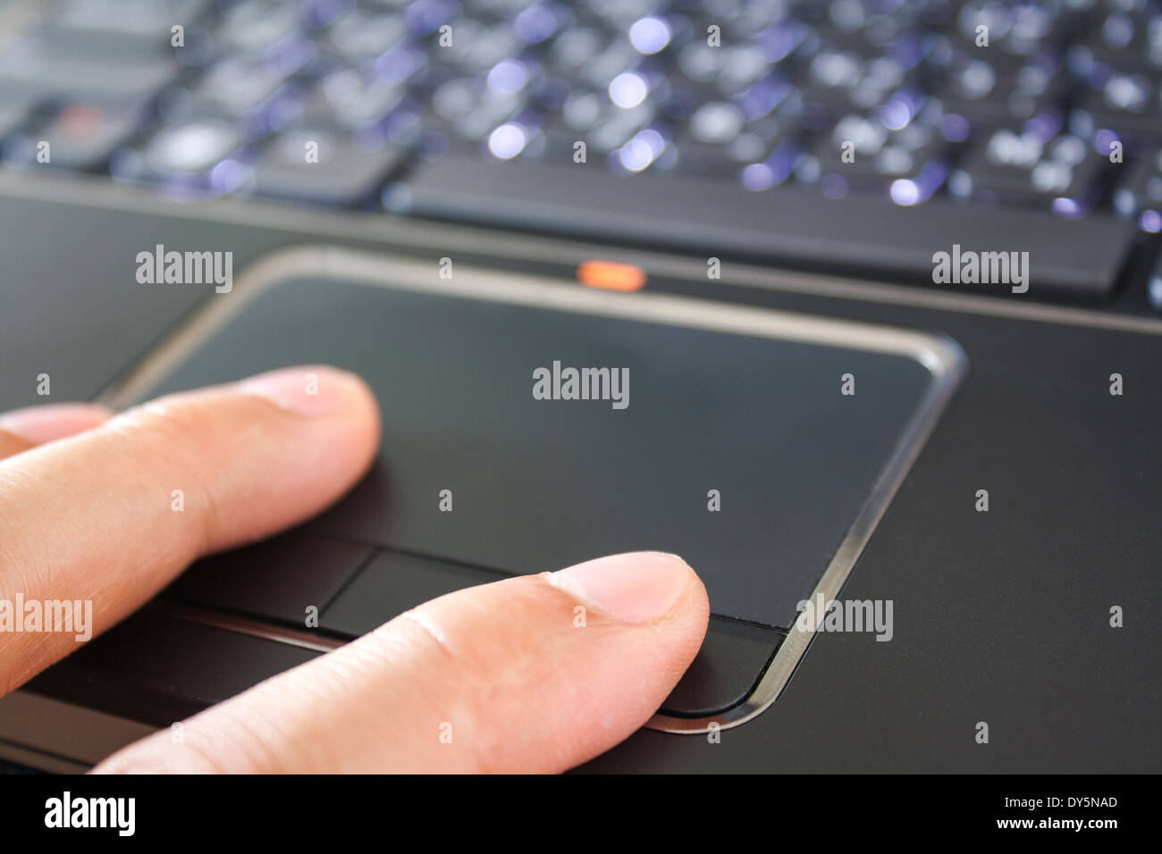 a hand is touching the laptop touchpad Stock Photo