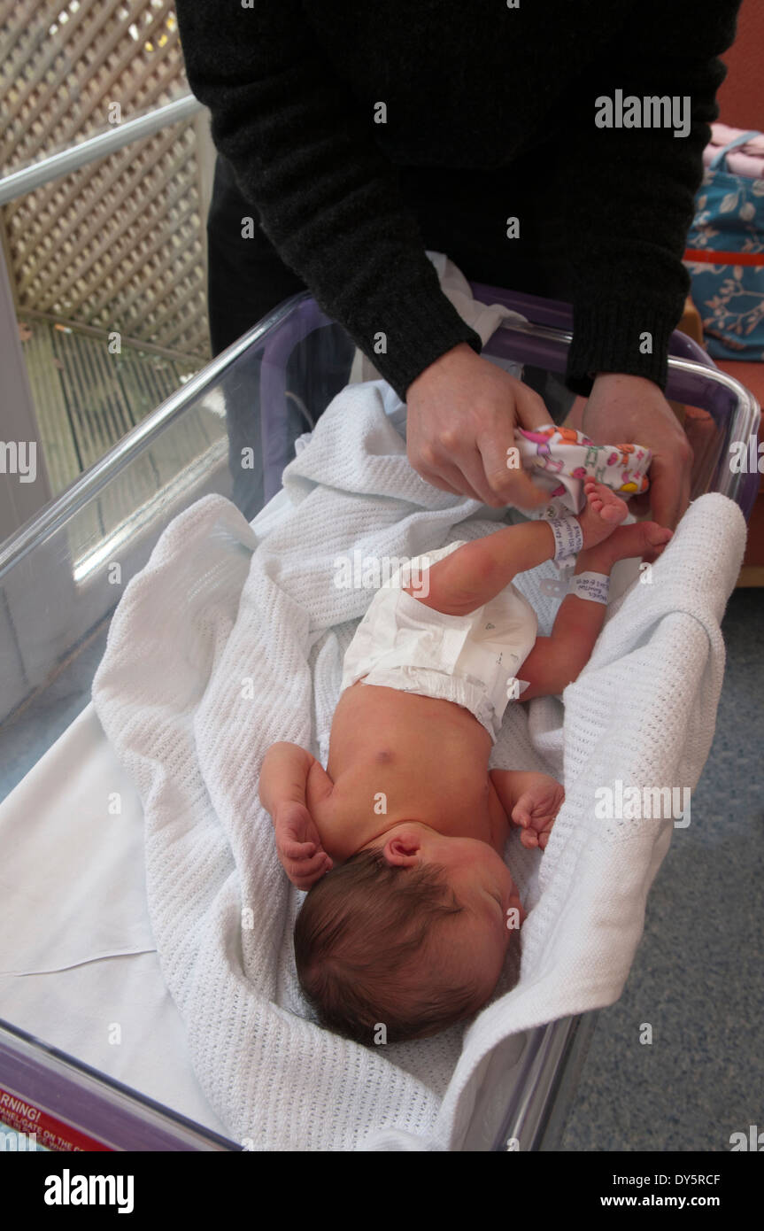Newborn baby girl being dressed for the first time by her father Stock ...