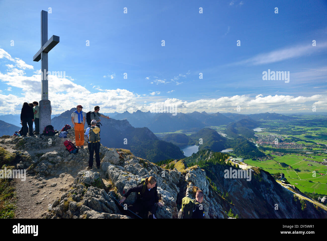 Hikers standing on the summit of Tegelberg, view to Fuessen, Tegelberg, Ammergau range, Allgaeu, Swabia, Bavaria, Germany Stock Photo