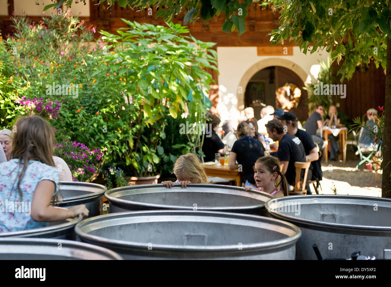 Barrels and people in front of a Strausse, traditional small restaurant, Markgraeflerland, Black Forest, Baden-Wuerttemberg, Ger Stock Photo