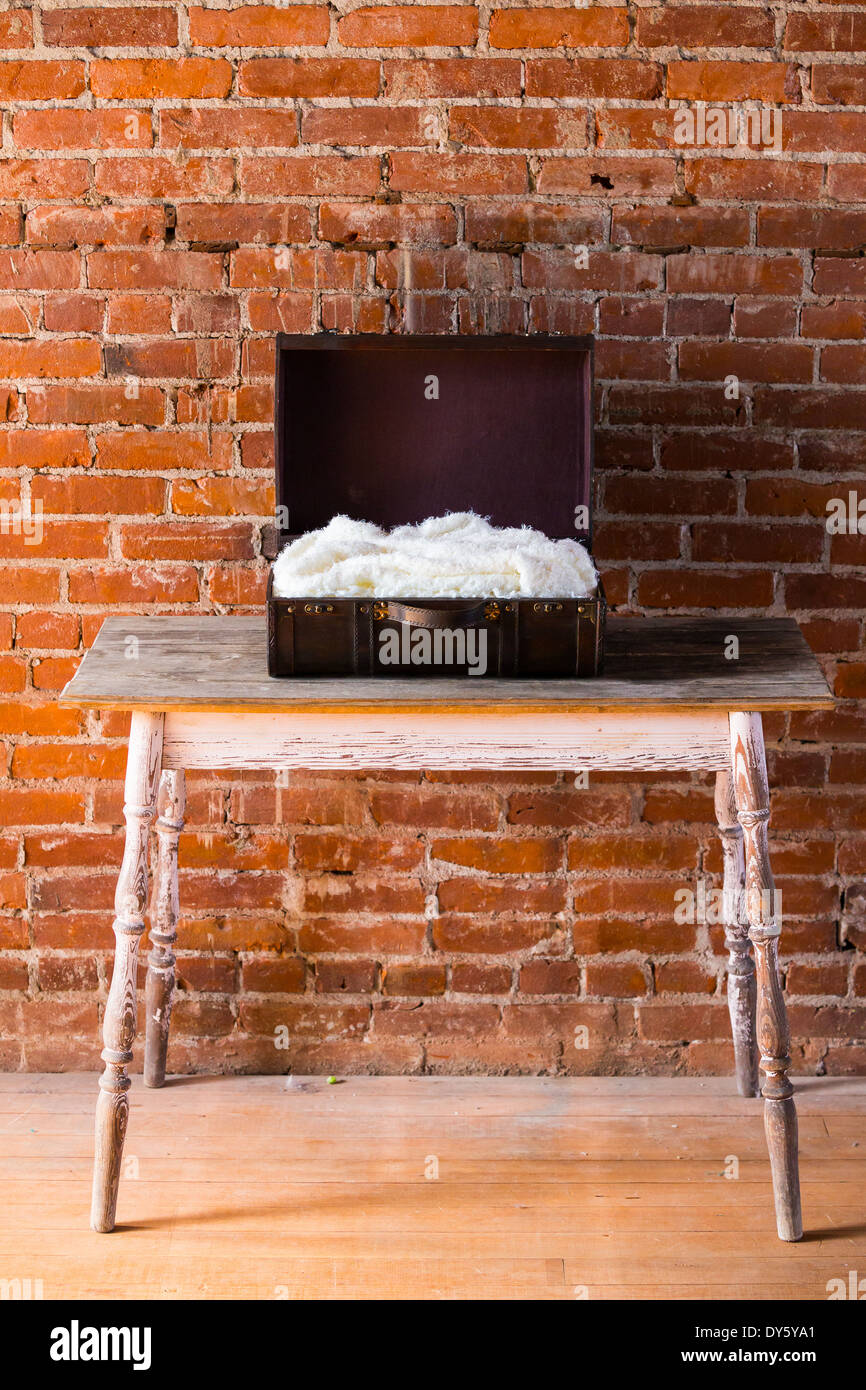 Antique box with a white blanket ready for a newborn baby during a child photo shoot. Stock Photo