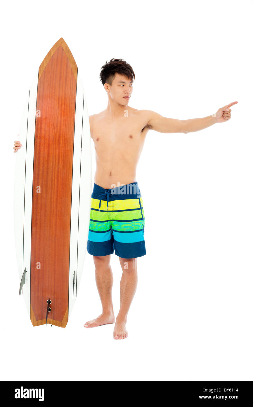young man standing and point forward with surfboard Stock Photo